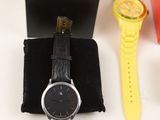 a black watch and a yellow watch sitting on a table