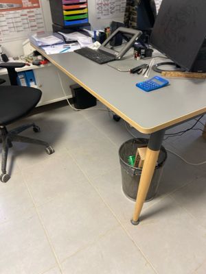 a desk with a computer and a chair in a room