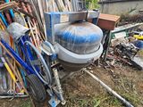 des toilettes posées dans l'herbe, à côté d'un tas de bric-à-brac
