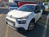 une petite voiture blanche garée dans un parking