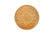 a gold coin on a white surface with a white background