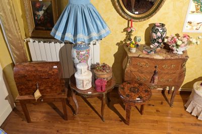une table, une lampe, une chaise et une commode dans une pièce