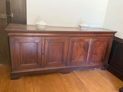 a wooden cabinet with a marble top in the corner of a room