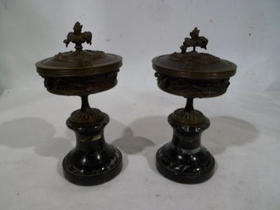 deux vases noirs posés sur une table à fond blanc