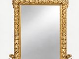 un miroir à cadre doré orné d'un motif décoratif sur le pourtour