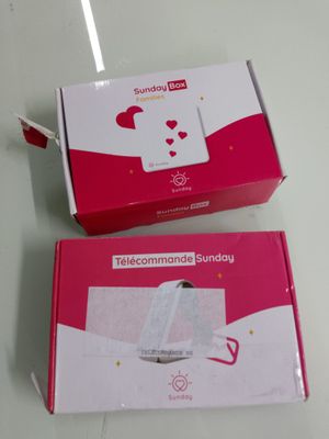deux boîtes ornées d'un motif blanc et rose, posées sur une table