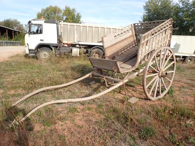 une charrette en bois posée dans l'herbe à côté d'un camion