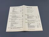 an open book with a menu on it sitting on top of a table