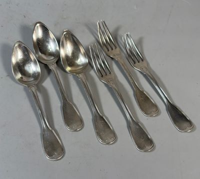 six cuillères et six fourchettes en argent sont alignées sur une table