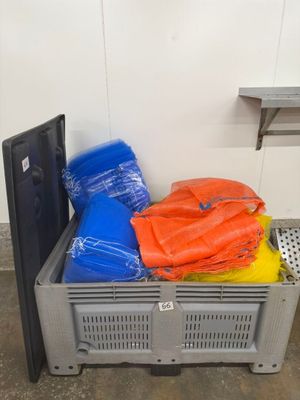 une caisse en plastique remplie de sacs orange et bleus