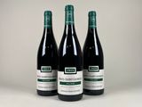 trois bouteilles de vin posées sur une table blanche