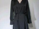 une robe noire sur un pied de mannequin, posée sur un mannequin