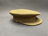 Le chapeau est de couleur beige et comporte un bouton sur le côté.