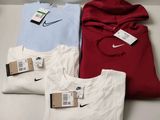 three shirts are sitting on a table with a price tag attached to them