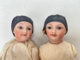 two dolls that are sitting next to each other