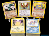four pokemon cards are sitting on top of each other on a table