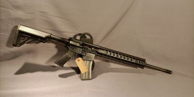 the rifle is sitting on a white sheet and ready to be used