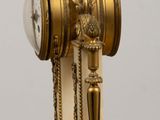 a gold and white clock sitting on a wooden table