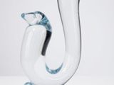 une sculpture en verre représentant un oiseau posé sur un rocher