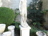 a statue of a woman standing next to a couple of vases