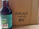 a bottle of coffee sitting on the floor next to a cardboard box