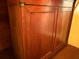 une armoire en bois avec un plateau noir, placée dans un coin de la pièce