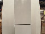 a white refrigerator sitting on a pallet in a warehouse