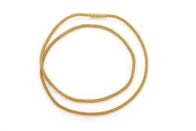 un collier en or avec une corde tressée sur fond blanc