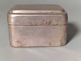 a small metal box with a lid on a table