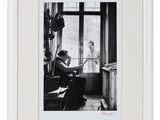 une photo en noir et blanc d'un homme et d'une femme assis devant une fenêtre