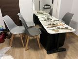 une longue table avec des chaises et une planche de surf posée dessus