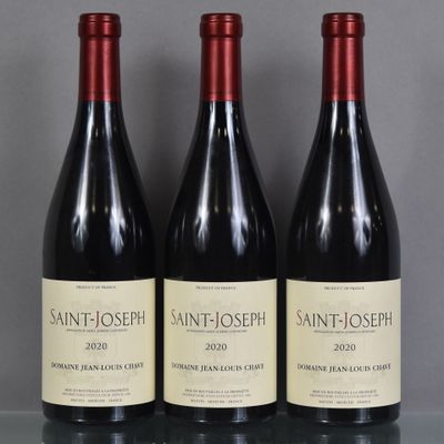 trois bouteilles de vin de Saint-Joseph sont posées sur une table en verre