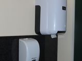une photo d'une salle de bains en noir et blanc avec un distributeur de papier toilette fixé au mur
