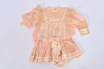 Une image représentant la robe d'une poupée est représentée sur un fond blanc.