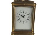 a gold clock with roman numerals on the face
