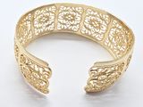 a close up of a gold cuff bracelet on a white background