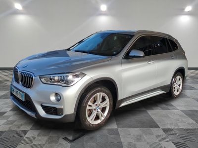 a silver bmw suv parked in a garage with a checkered floor
