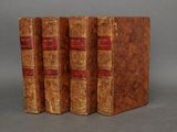 trois vieux livres empilés les uns sur les autres sur une surface grise