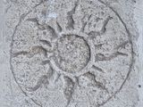 a stone block with a sun design on it