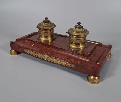 une image représentant un ensemble de bureau rouge et or, orné de deux bougies