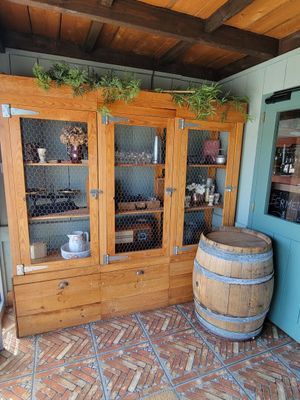 a wooden cabinet with glass doors and a wooden barrel on the floor