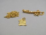 three pieces of gold are sitting on a table next to each other