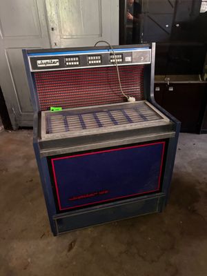 un juke-box bleu et rouge posé sur le sol d'un garage