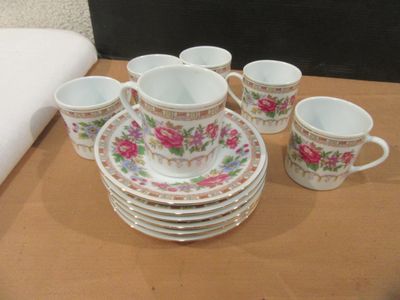a lot of cups and saucers sitting on a table
