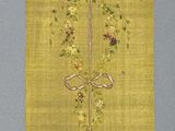 un papier jaune orné d'un motif doré, accroché au mur