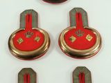 six red and blue buttons with gold trims on a white surface
