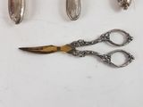 a pair of scissors and a pair of spoons next to each other