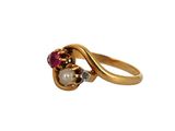 a close up of a gold ring with a pearl and ruby stones