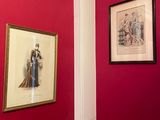 two framed pictures on a red wall in a bathroom