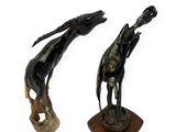 pair of bronze sculptures of a giraffe and a horse on a wooden base